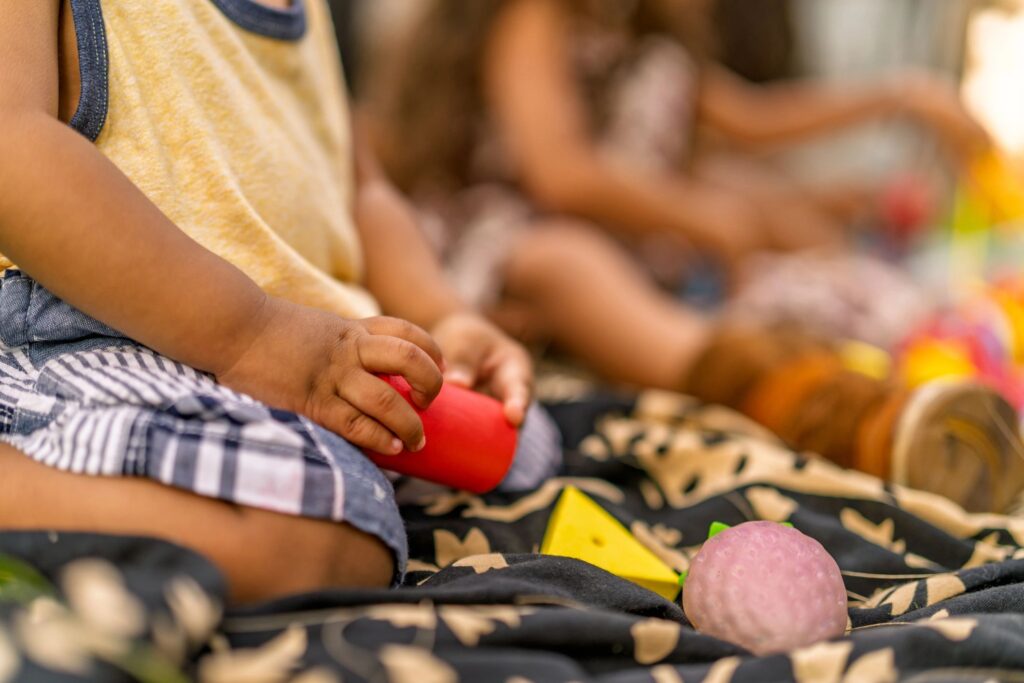 Babies playing together on picnic blanket outdoors